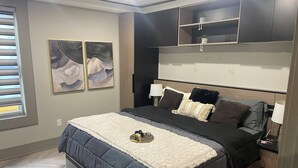 Un dormitorio moderno con cama, mesitas de noche, una estantería en la pared con plantas y arte abstracto en la pared.