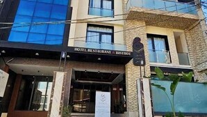 A multi-story hotel with a modern facade, featuring large windows and a prominent entrance with a sign for a restaurant and bistro. - RV Hotel - Dely Brahim (Algiers)