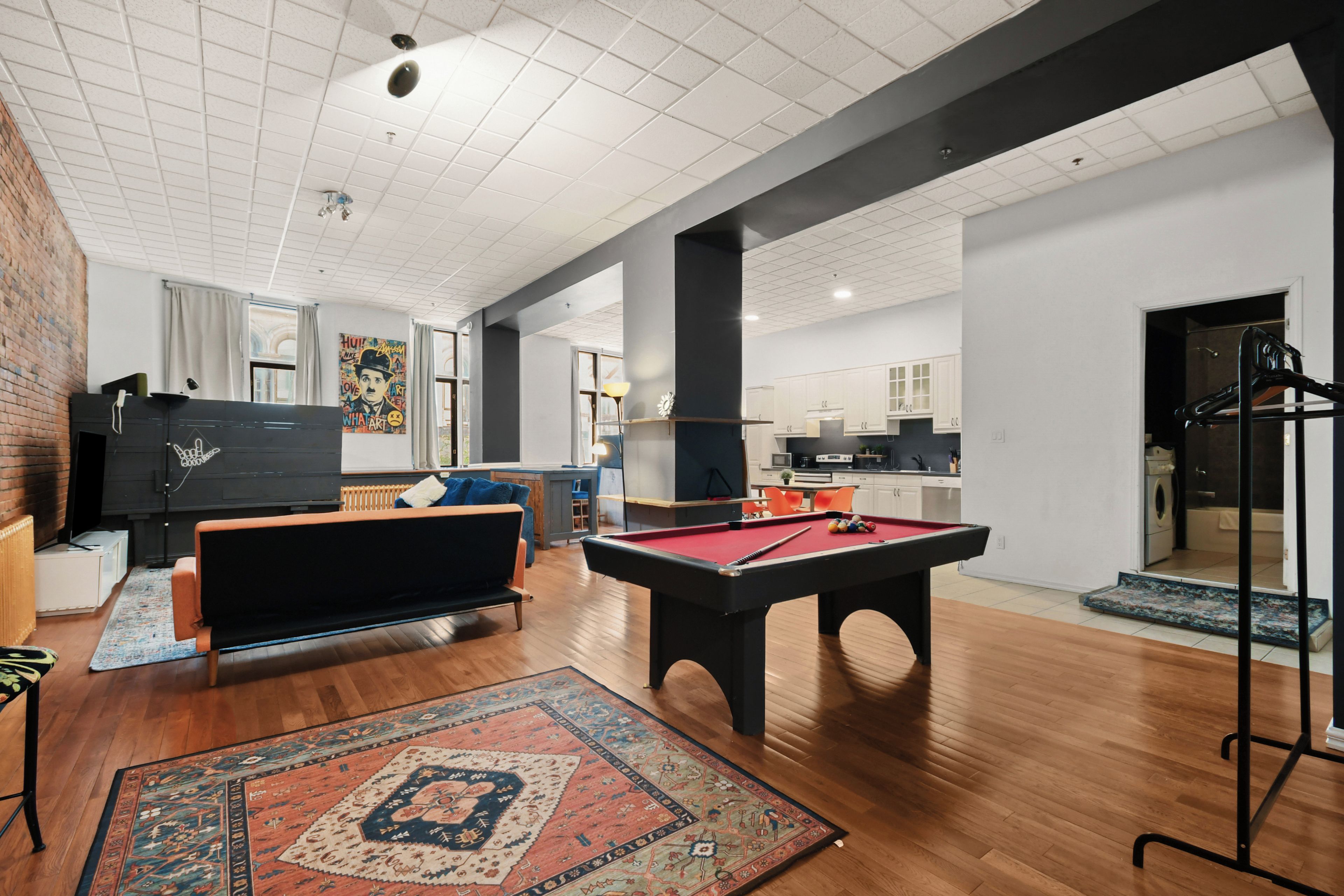 A spacious living area with a pool table, a sofa, and a coffee table.