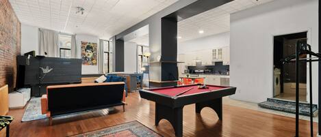 A spacious living area with a pool table, a sofa, and a coffee table.