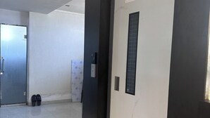 Ένας διάδρομος με μια πόρτα στην οποία αναγράφεται: «Παρακαλούμε αφαιρέστε την προστατευτική μεμβράνη εντός 6 μηνών από την ημερομηνία παράδοσης».