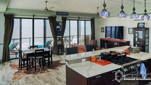 Una cucina moderna con un'isola grande, zona pranzo con vista e soggiorno con televisore e arredamento.