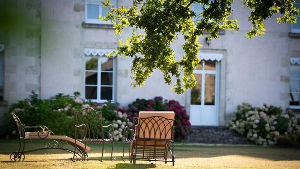 A garden with outdoor furniture and a building in the background. - Chambre Colibri, Country panorama and refined comfort at Domaine de la Briouse (Sanxay)