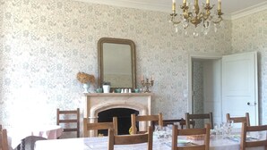A dining room with a wooden table set for six, a fireplace, and a chandelier. - Chambre Colibri, Country panorama and refined comfort at Domaine de la Briouse (Sanxay)