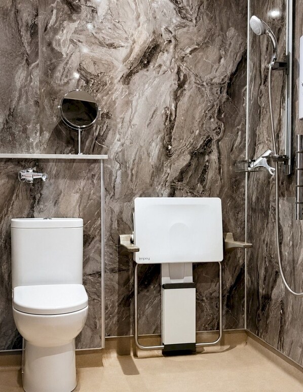 Une salle de bain avec des toilettes, un lavabo et une douche.