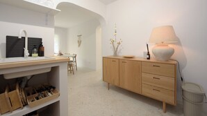 Una cocina moderna con un mueble de madera, un lavamanos y una zona de comedor al fondo.