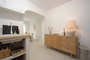 Eine moderne Küche mit einem Holzkorpus, einer Spüle und einem Essbereich im Hintergrund.