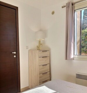 1 dormitorio y tabla de planchar con plancha