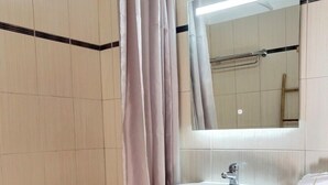 Une salle de bain avec une baignoire, un lavabo et un miroir.