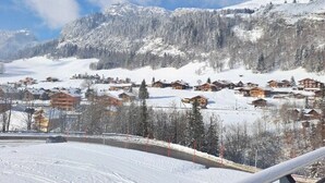 A snow-covered mountain village with wooden houses and a clear sky. - Stay at the slopes, stunning mountain views! (Le Grand-Bornand)