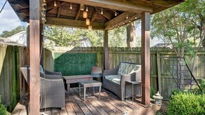 Una pergola in legno con mobili in vimini e luci a stringa.