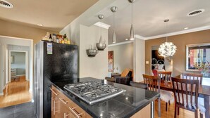 Una cucina moderna con isola centrale, elettrodomestici in acciaio inossidabile e luci a sospensione.