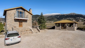 A stone building with a balcony, a small gazebo, and a parked car. - Anemos Mountain Villa - Your Perfect Mountain Retreat (Arachova)