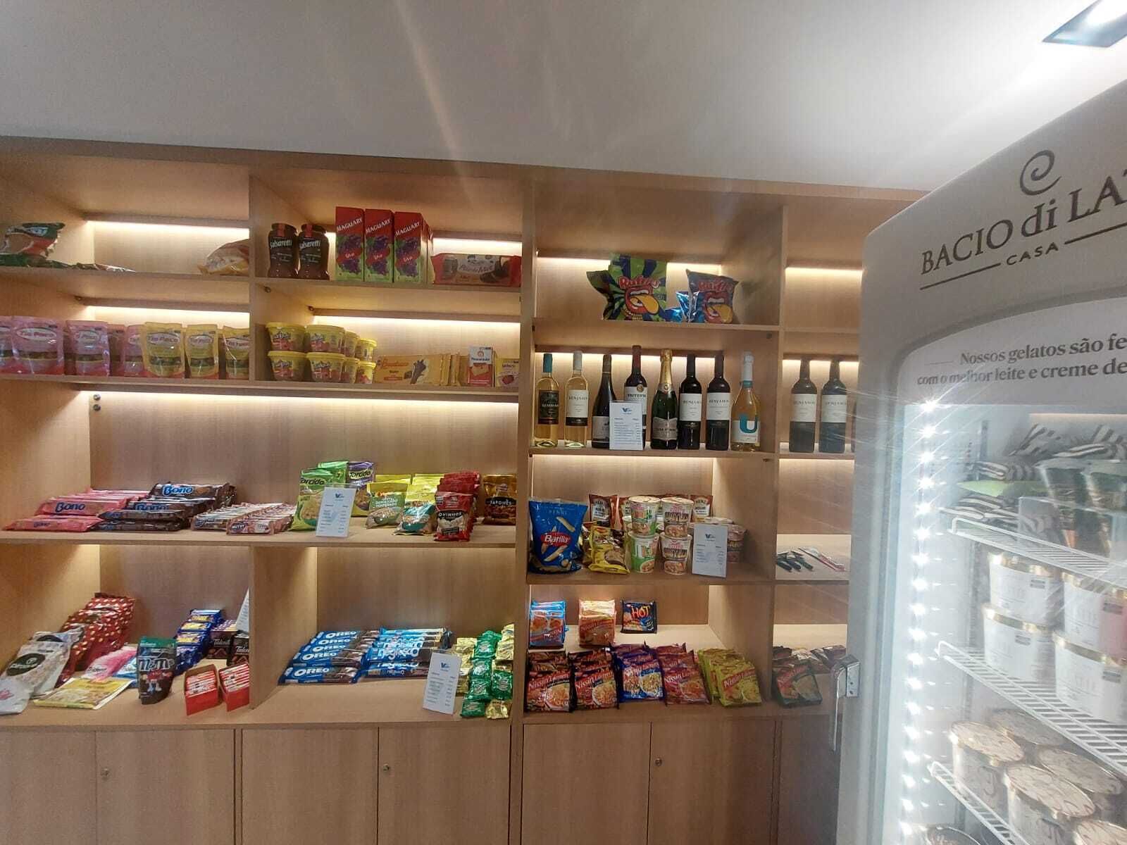 Een winkel met schappen vol snacks, drankjes en verpakte producten.
