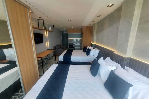 Habitación cuádruple Deluxe, vista al mar | Caja de seguridad en la habitación y escritorio