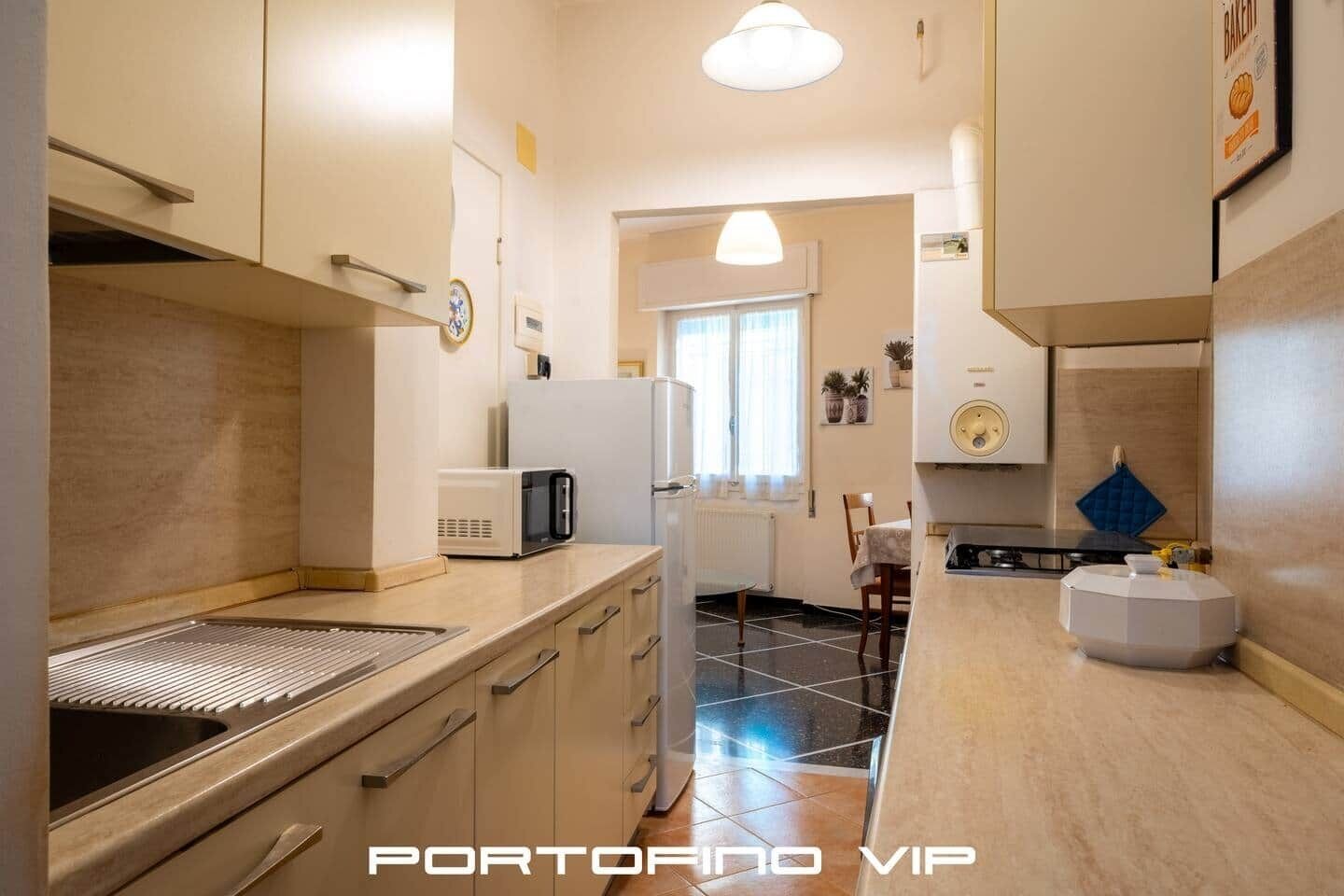 Angolo cottura attrezzato con forno a microonde, frigorifero e lavello.