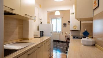 Angolo cottura attrezzato con forno a microonde, frigorifero e lavello.