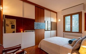 A bedroom with a bed, a chair, a desk, and a window with blinds. - Luca's Corner by PortofinoVip [AC-Parking]. (Rapallo)