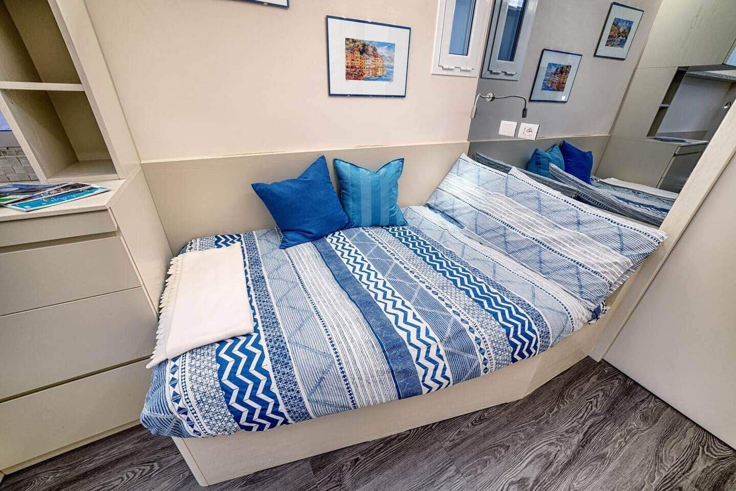 Un dormitorio con cama, almohadas, cómoda y espejo.
