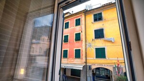 A window view of a building with a yellow facade, green shutters, and a sign reading "AZIENDA AVTONOMA DI SOCCORSO". - La Casetta by PortofinoVip [AC-Super central]. (Portofino)