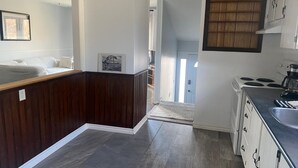 A modern kitchen with dark wood cabinetry, a central island, and a view into the dining area. - Home Away from Home - Relax and unwind in this beautifully decorated 3-bedroom (Kingston)