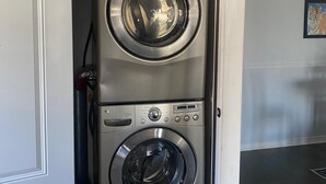 A compact, modern laundry room with two stacked front-loading washing machines. - Home Away from Home - Relax and unwind in this beautifully decorated 3-bedroom (Kingston)
