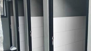 A hallway with doors, trash bins, and a doormat.