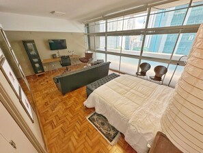 A spacious bedroom with a large bed, a sofa, a desk, and a TV. - 0516B (São Paulo)