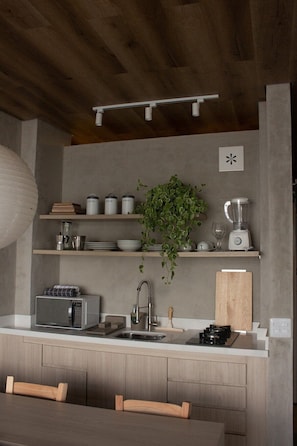 A modern kitchen with a built-in microwave, a sink, and a countertop with various items. - 3209B (São Paulo)