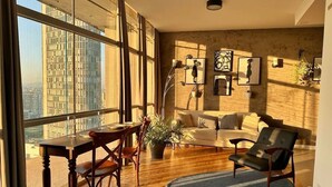 A spacious living room with a large window, a dining area, and a seating area with a sofa and armchairs. - 2319B (São Paulo)