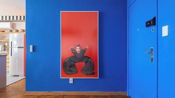 A hallway with a blue wall and a framed artwork.