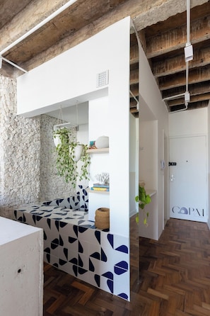 A modern interior with a stone wall, a patterned tile bench, and a wooden floor. - 1609B (São Paulo)