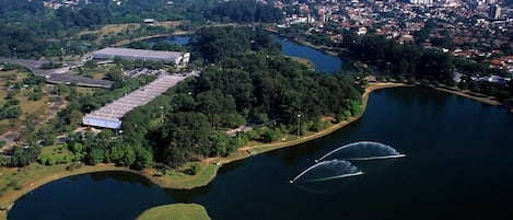 Une vue aérienne d’une ville avec un grand lac, entourée de verdure et de quelques bâtiments.
