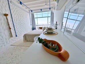 A modern interior with a white table, a plant, and a view through a large window. - 3105B (São Paulo)