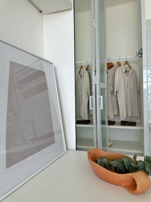 A modern bathroom with a glass shower enclosure, a framed picture on the wall, and a terracotta planter with green foliage. - 3105B (São Paulo)