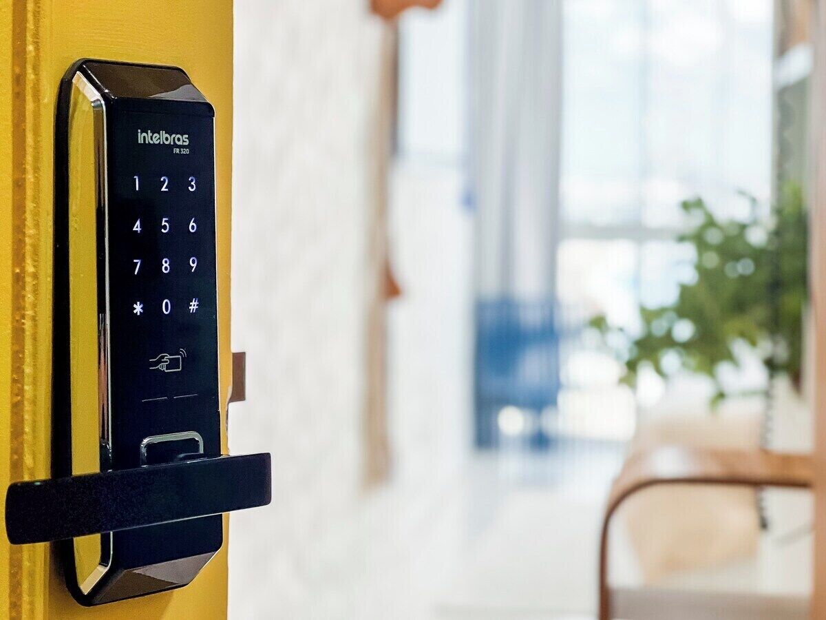 A wall-mounted electronic keypad, likely for a door lock, with a numeric keypad and a few symbols.
