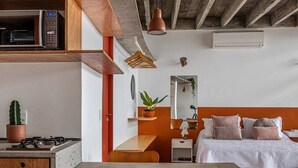 Eine moderne Küche mit einer Holzausziehtheke, einer eingebauten Mikrowelle und einer Pendelleuchte.