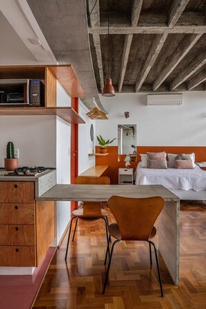 A modern kitchen with a wooden countertop, a built-in microwave, and a hanging light fixture. - 3017B (São Paulo)