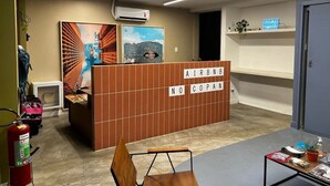 Ett receptionsområde med en skylt som visar texten ”AIRBNB NO COPAN” och en brandsläckare på vänster sida.