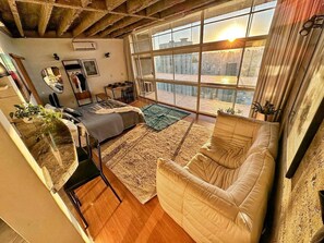A room with a large window, a sofa, a coffee table, and a mirror. - 2717B (São Paulo)