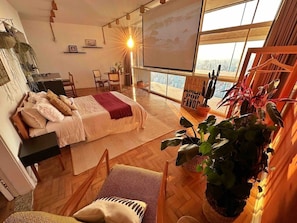 A modern bedroom with a bed, a desk, and a large window. - 2920B (São Paulo)