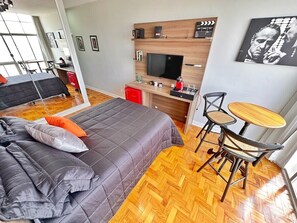 A bedroom with a bed, a desk, a chair, and a television. - 2303B (São Paulo)