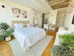 A modern bedroom with a large bed, a bedside table, a mirror, and a desk with chairs. - 2707B (São Paulo)