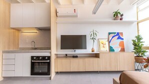 A modern kitchen with a built-in oven and a flat-screen TV on a wooden cabinet. - 2210B (São Paulo)