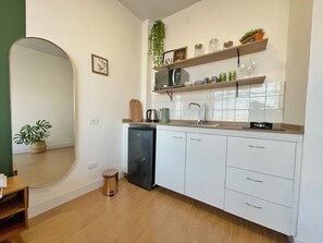 A compact kitchen with white cabinets, a microwave, a sink, and a small refrigerator. - 2709B (São Paulo)