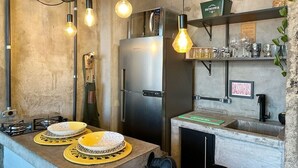 A kitchen with a stainless steel refrigerator, a sink, and a countertop with plates and a kettle. - 2903B (São Paulo)