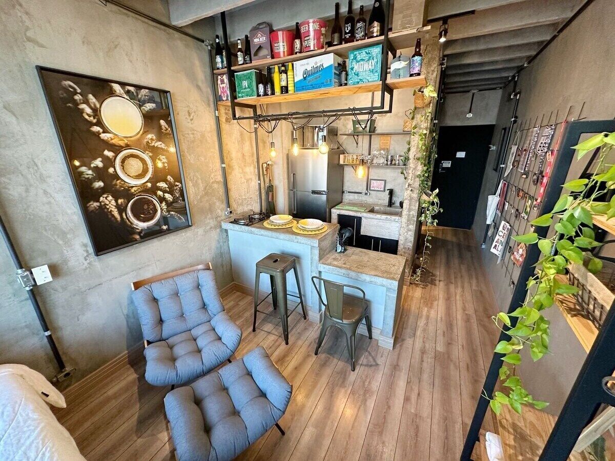 Una cuina compacta amb zona de bar, terra de fusta i seients.