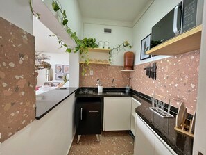 A compact kitchen with a refrigerator, sink, and microwave. - 2520B (São Paulo)