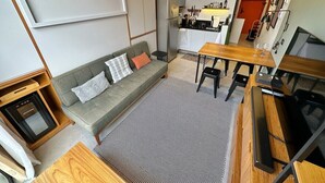 Een knus woongedeelte met een bank, eettafel en kitchenette.