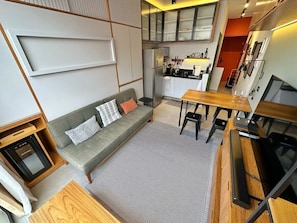 A compact living space with a sofa, dining table, and kitchenette. - 1305B (São Paulo)